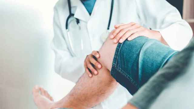 Un traumatólogo examina la rodilla de un paciente