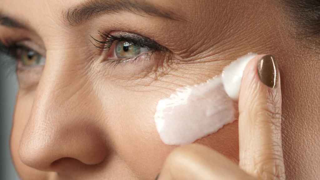 Mujer aplicándose una crema facial.