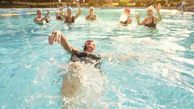 Una nadadora bañándose en una piscina exterior.