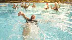 Una nadadora bañándose en una piscina exterior.