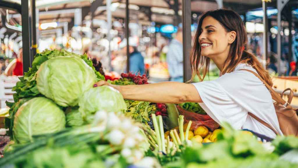 Una mujer mira el género en un mercado.