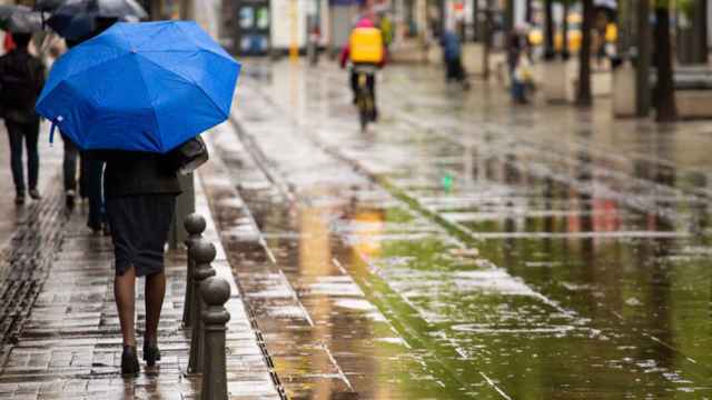 Una mujer pasea bajo la lluvia.