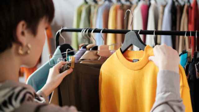 Una mujer mira ropa en una tienda.