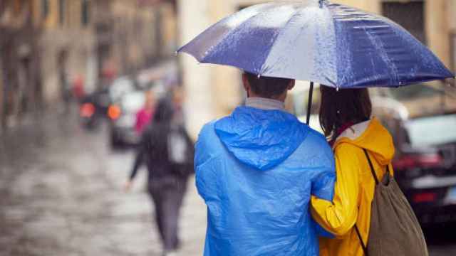 Una pareja se protege de la lluvia.