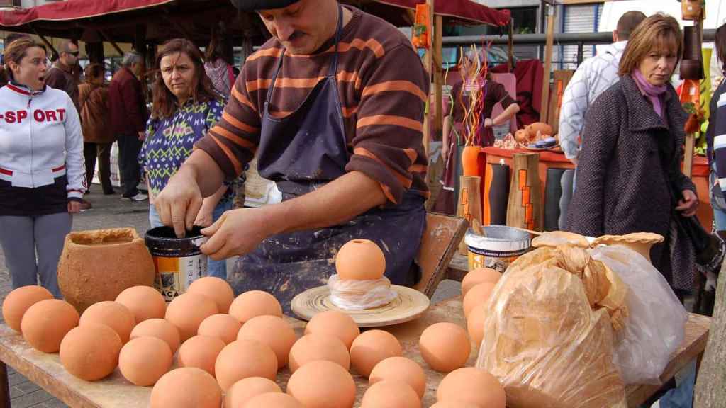 Un hombre realiza manualidades en el mercado navideño del Muelle de Ripa.