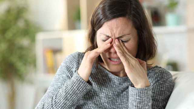 Una mujer se frota los ojos a causa del malestar en los párpados