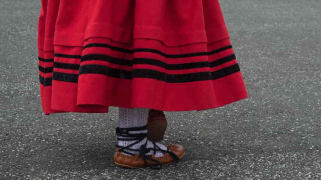 Mujer vestida con el traje tradicional vasco a punto de realizar el baile típico.