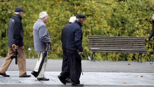 Pensionistas y jubilados pasean por un parque en Bilbao.