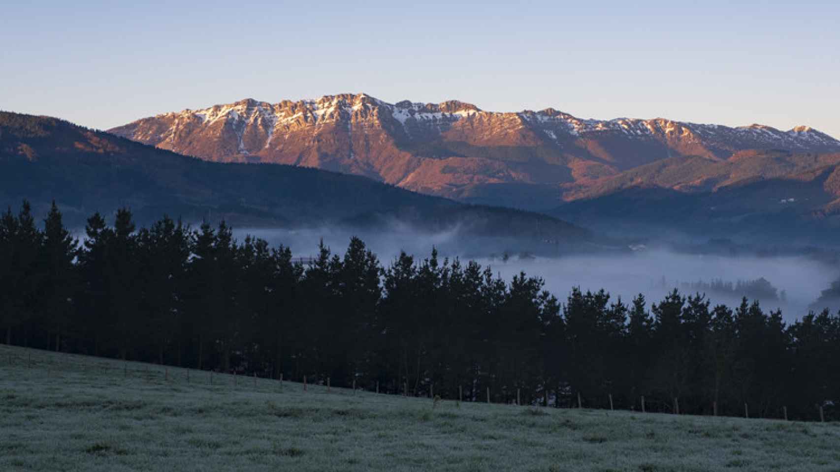 Prados en Olaberria con la sierra de Aizkorri al fondo al amanecer, Euskadi.