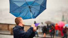 A un hombre se le vuela el paraguas debido a los fuertes vientos.