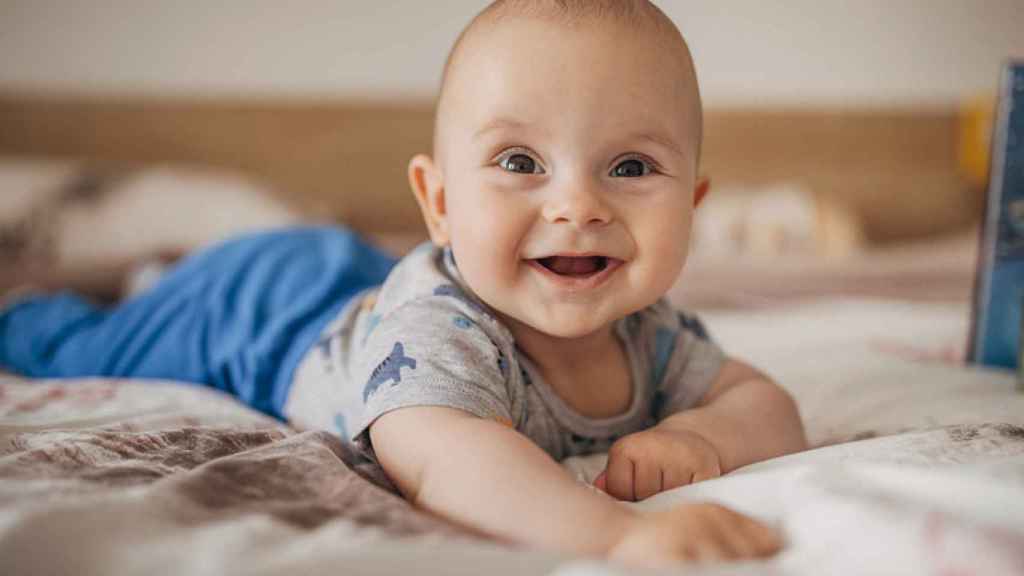 Un niño acostado sobre una cama.