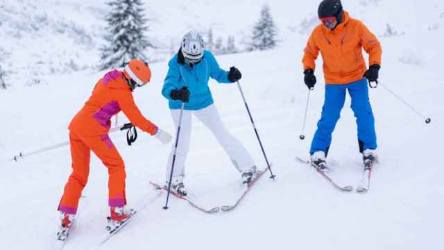Tres esquiadores se divierten en la nieve.
