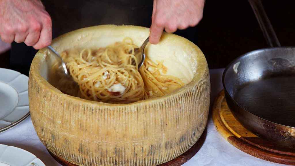 Un chef prepara la pasta dentro de una rueda de queso.