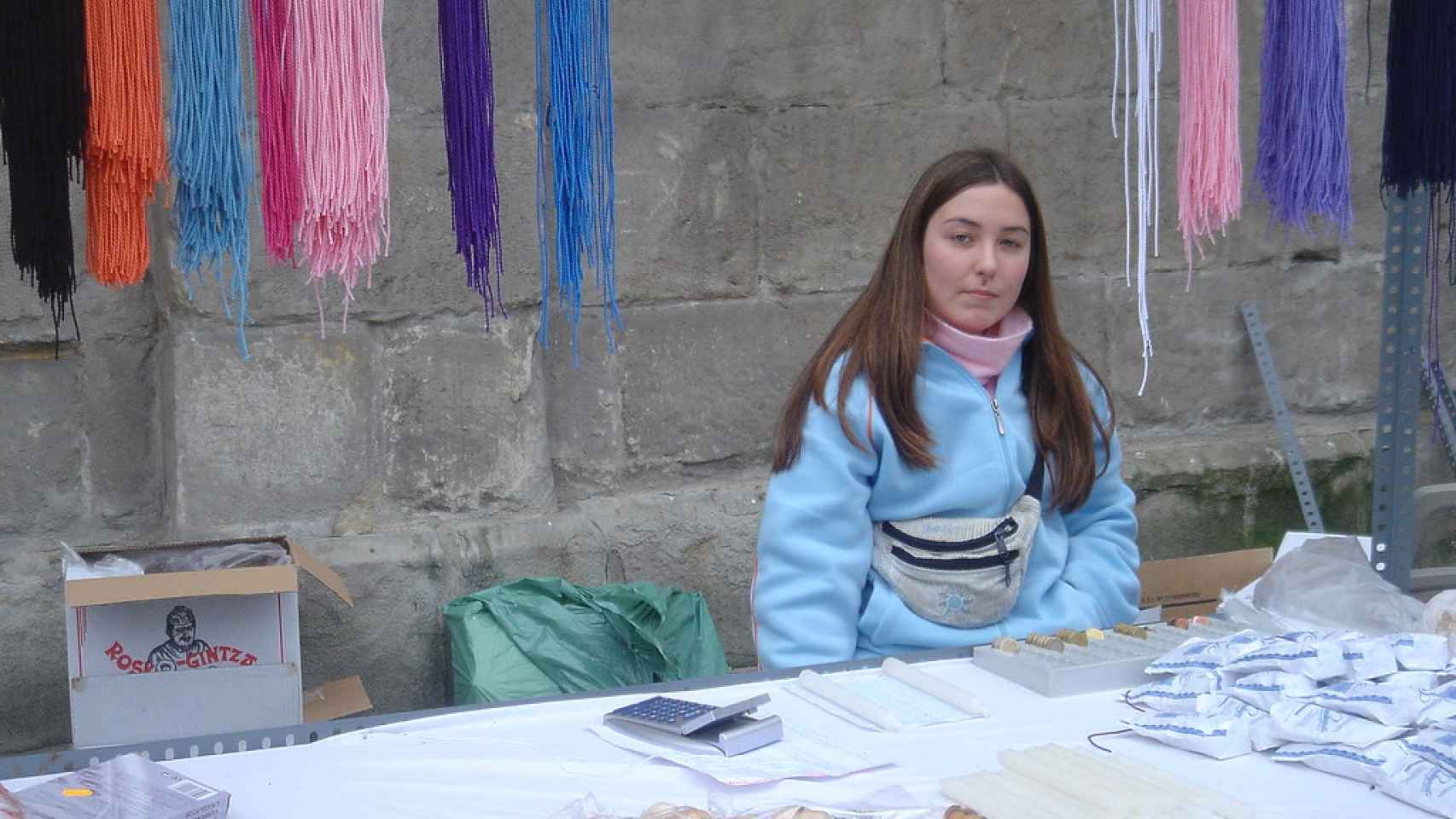 Una joven vende dulces típicos y cordones por el día de San Blas en Bilbao.