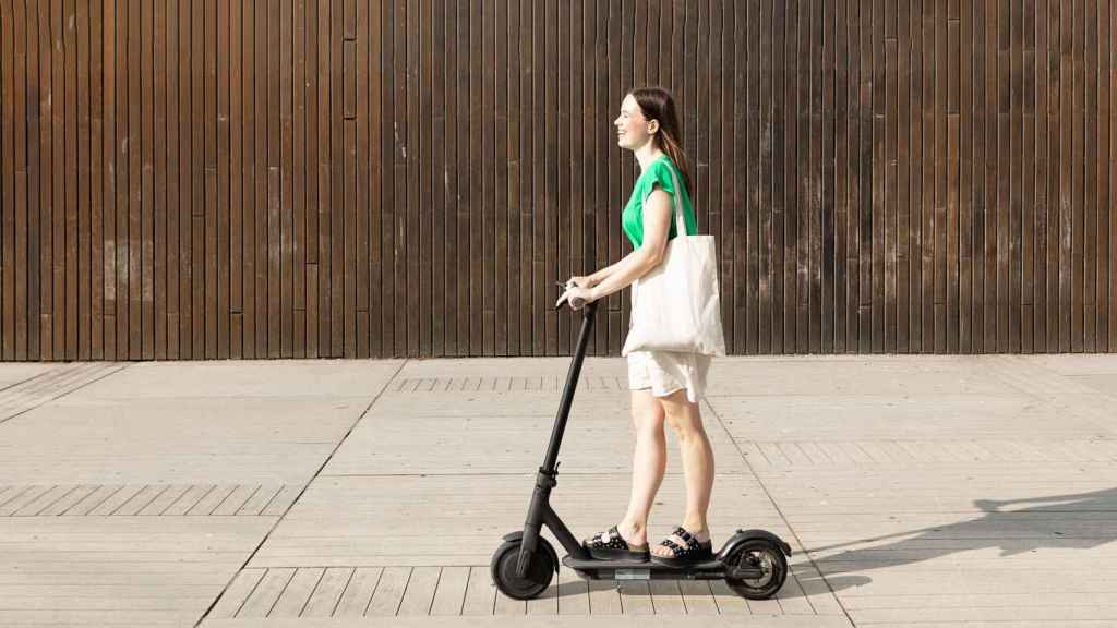 Una mujer anda en patinete eléctrico.