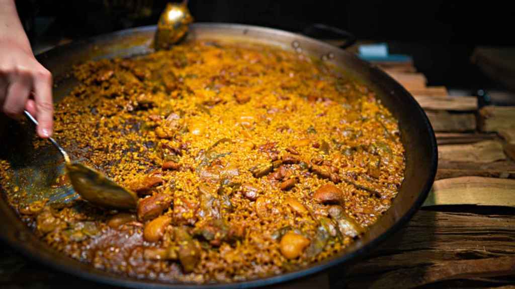 Un camarero sirve la paella tradicional valenciana.