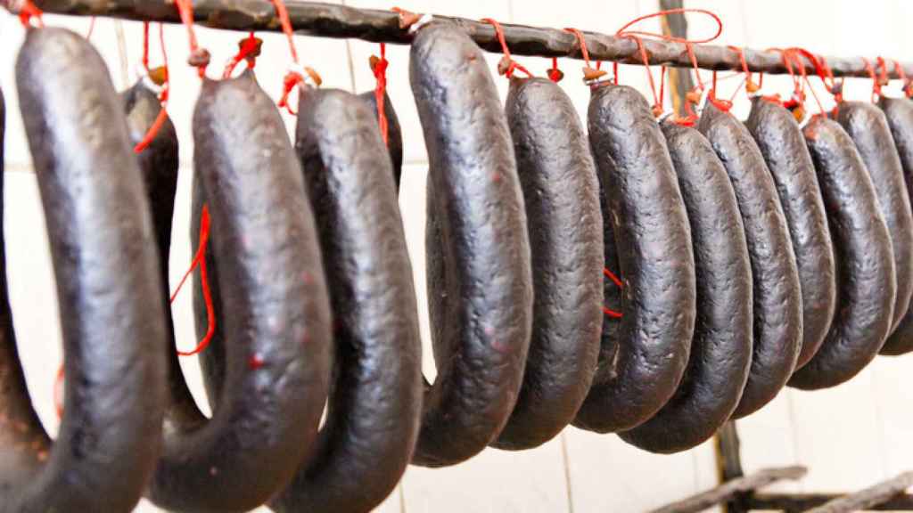 Morcillas recién preparadas y colgadas en una carnicería.