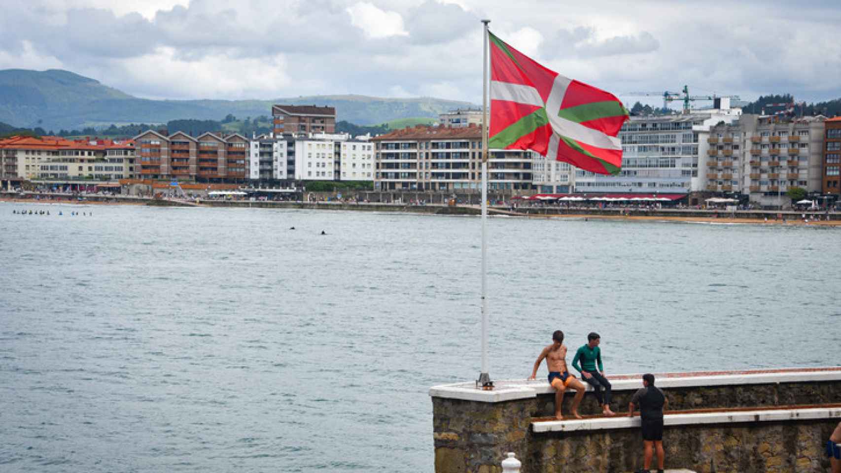 Adolescentes en las murallas del puerto en la ciudad de Zarautz, en Euskadi.