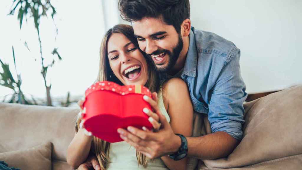 Una mujer recibe un regalo por parte de su pareja por el día de San Valentín.