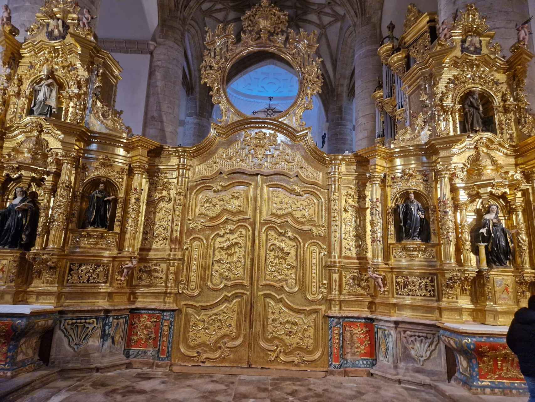 La actual puerta rococó de acceso al altar se añadió en el siglo XVIII en sustitución de la antigua reja. Así se daba mayor privacidad a los monjes benedictinos que habitaban entonces en el monasterio / A. VIRI
