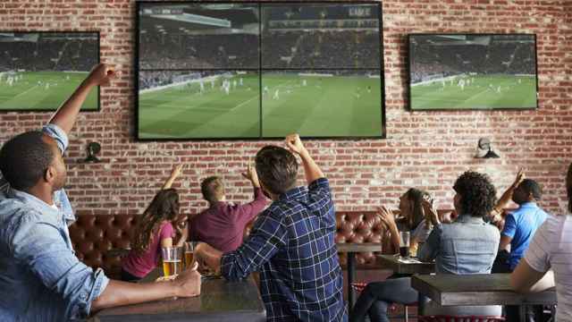 Aficionados viendo un partido de fútbol en un bar