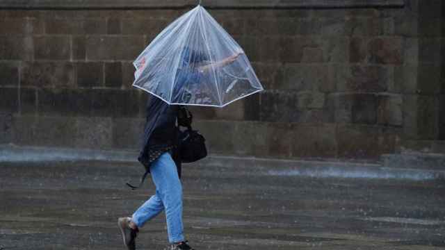 Una mujer se protege de la lluvia.