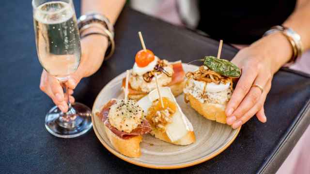 Una mujer disfruta de una variedad de pinchos.