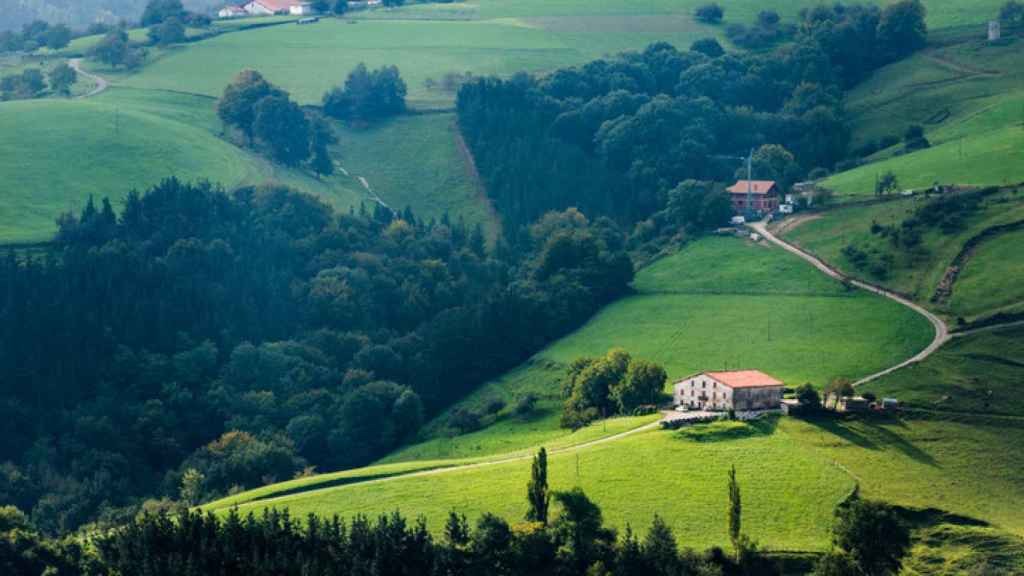 Vista de los prados verdes y Landa Etxeas de Aia.