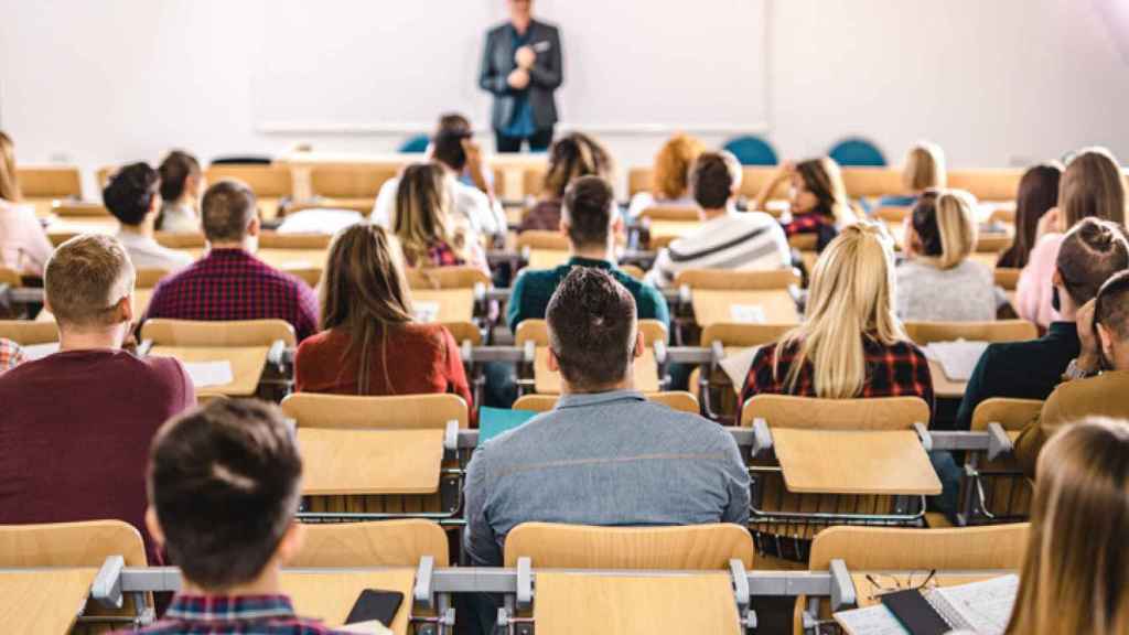 Unos alumnos atienden a un profesor en la universidad.