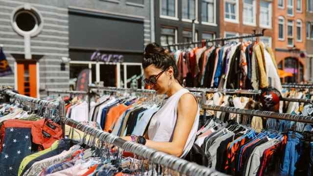 Una mujer compra en un mercadillo de ropa al aire libre.