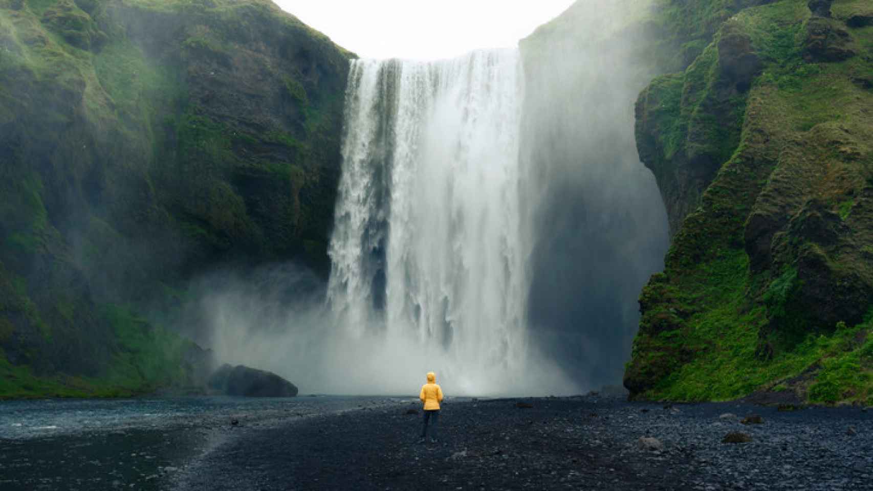 Una mujer en la cascada Skogafoss de Islandia.