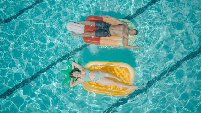 Una pareja disfrutando de una piscina | PEXELS