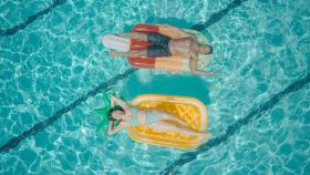 Una pareja disfrutando de una piscina | PEXELS