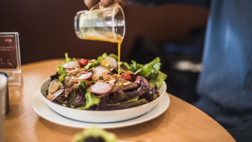 Un hombre se aliña su ensalada.