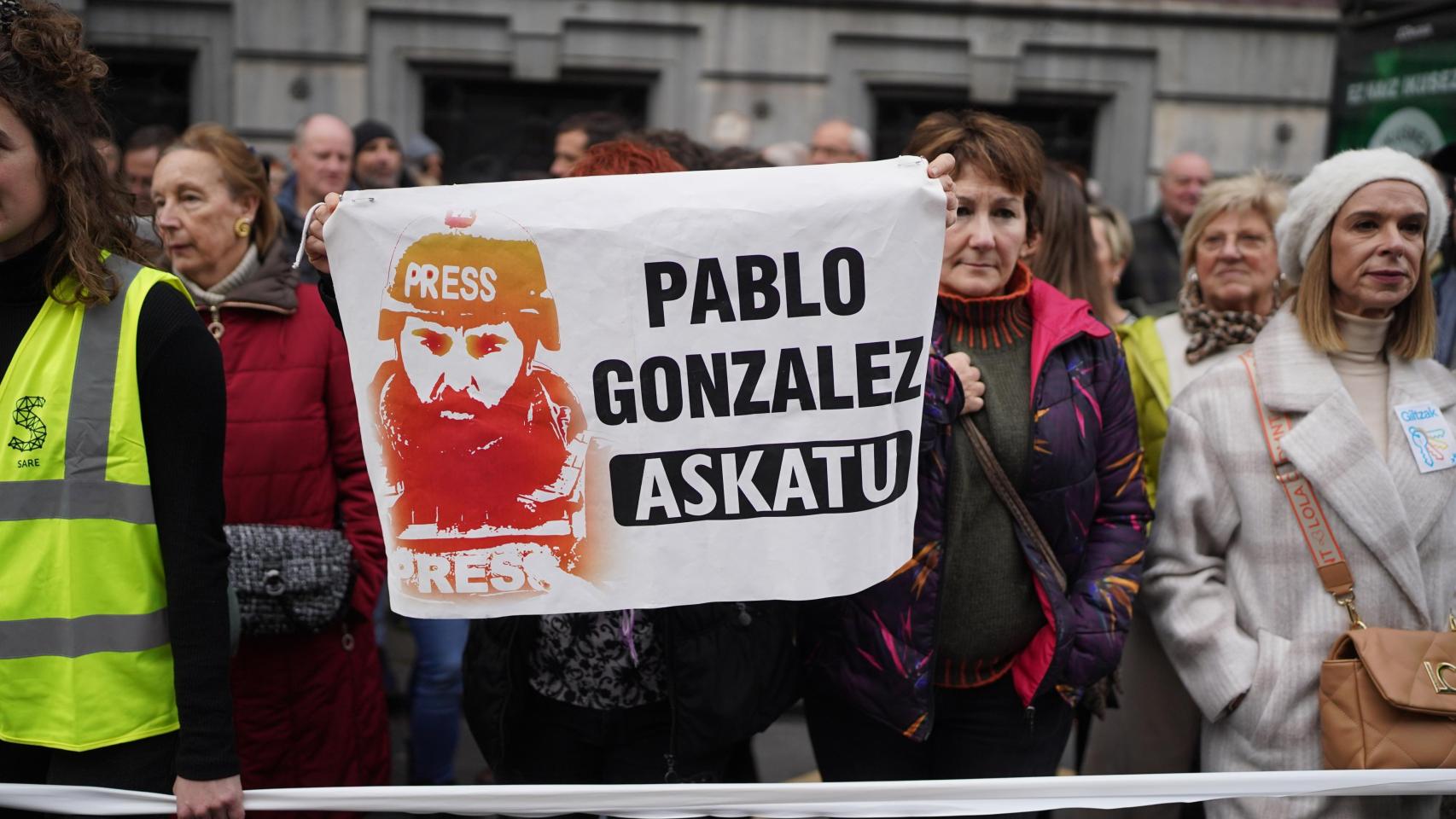 Varias personas sujetan un cartel con la cara del periodista Pablo González durante una manifestación en Bilbao.