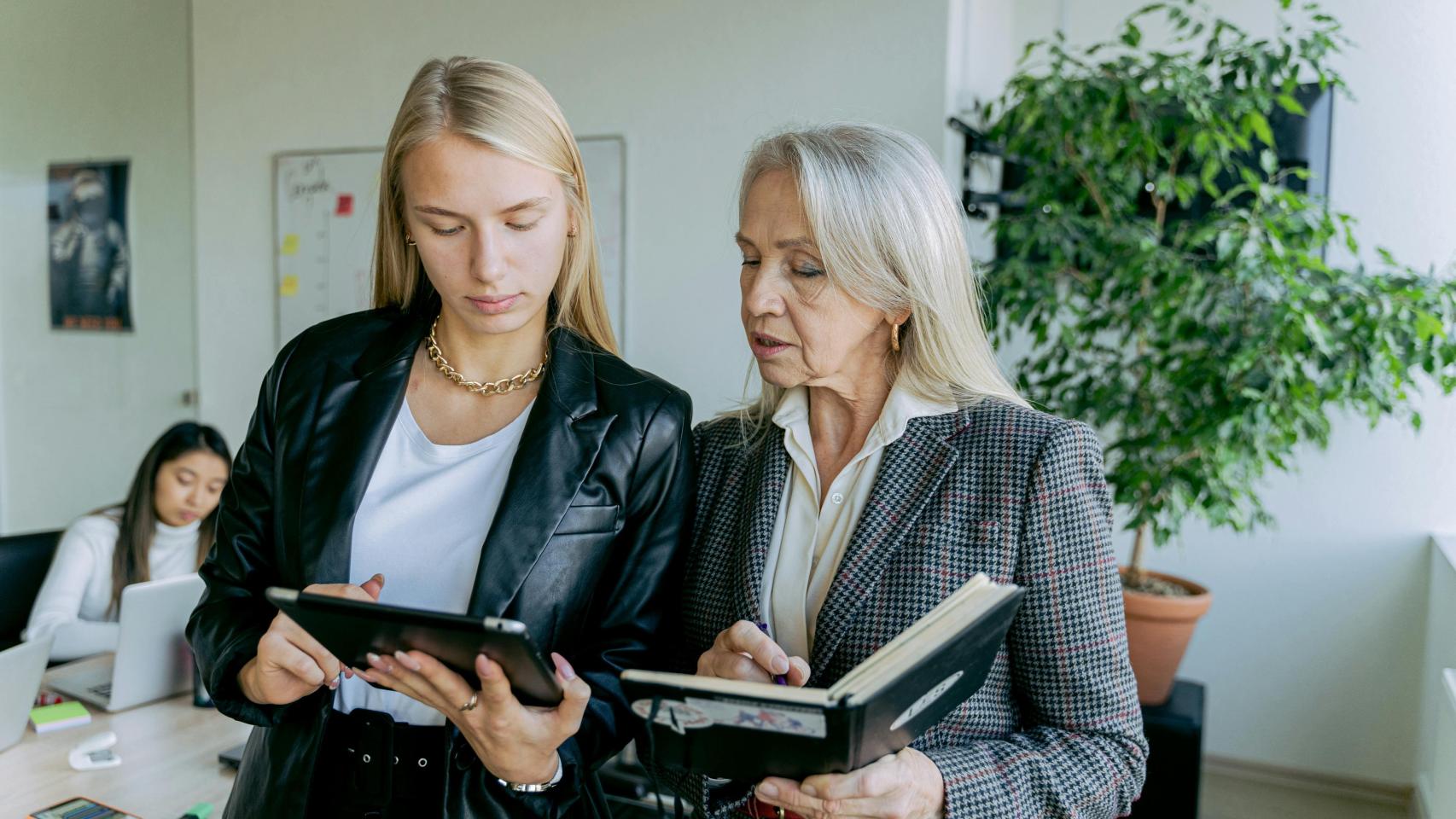 Dos personas de generaciones diferentes trabajan juntas en una oficina