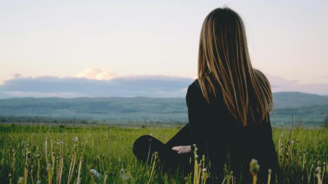 Una mujer reflexiona en el campo.