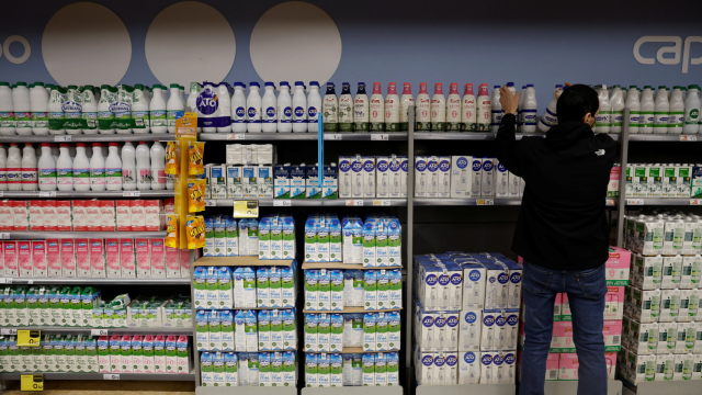 Un hombre escoge la leche en un supermercado.