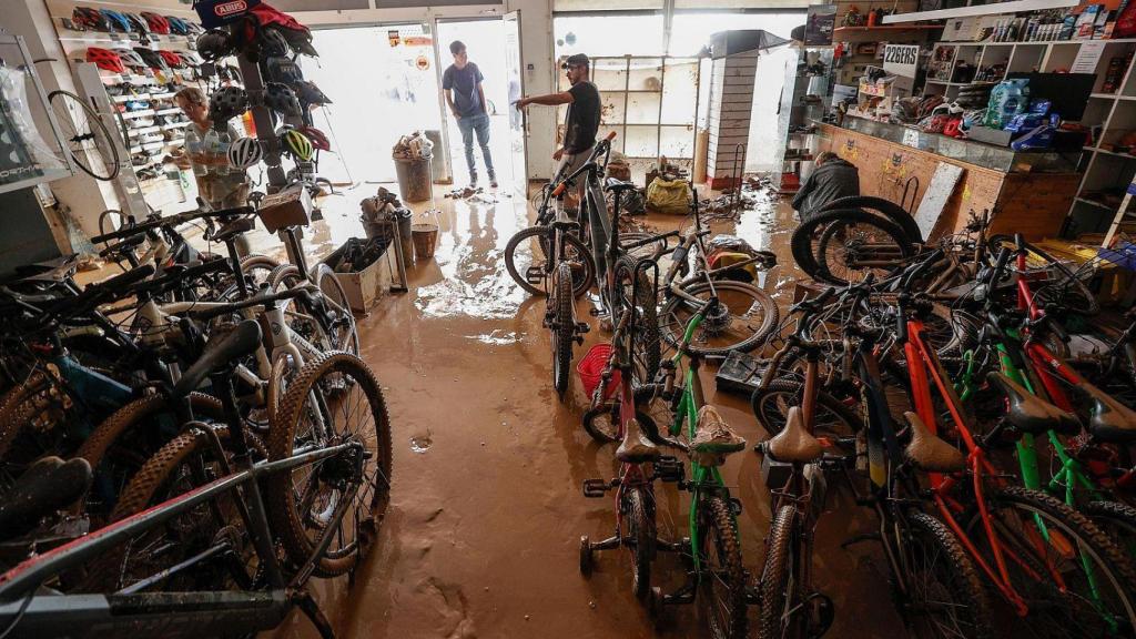 Varias personas evalúan los destrozos causados en el interior de su comercio en Catarroja