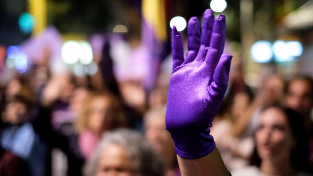 Una mano con un guante levanta en una manifestación contra la violencia de género