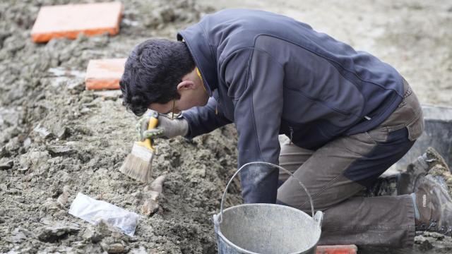 Un voluntario de la Sociedad de Ciencias Aranzadi limpia restos mortales en el Cementerio de Orduña (Bizkaia) en diciembre de 2024