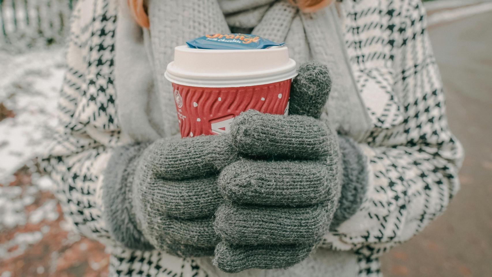 Mujer abrigada con abrigo y guantes para protegerse del frío