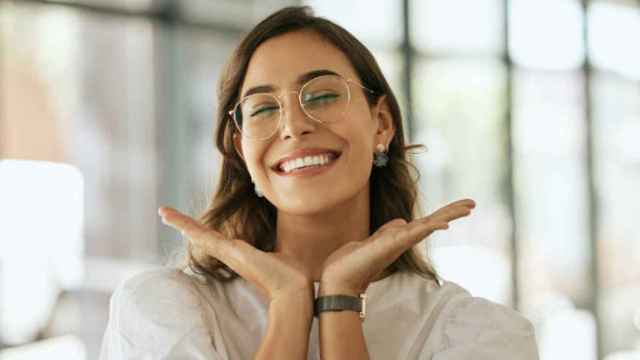 Una mujer feliz posa delante de la cámara.