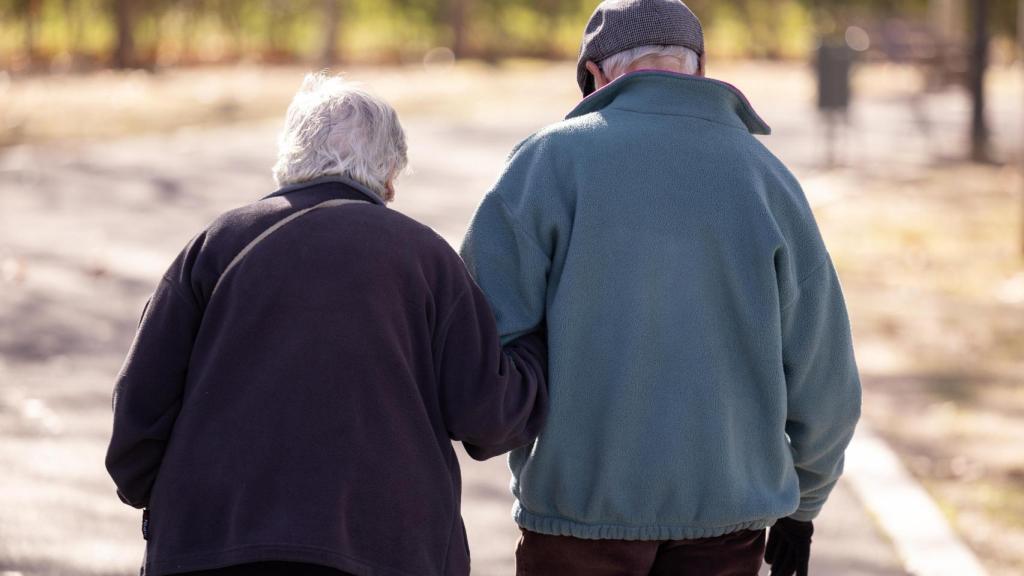 Dos personas mayores pasean por la calle