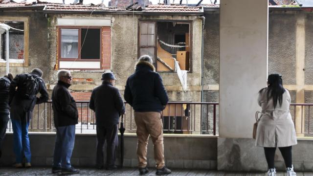 Vecinos de Basauri observan los daños ocasionados por el incendio del inmueble / LUIS TEJIDO - EFE