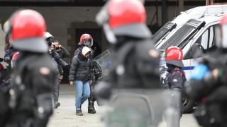 La Ertzaintza se lleva a uno de los arrestados en el gaztetxe Etxarri de Bilbao.