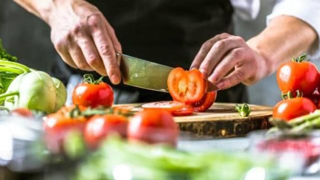 Un chef parte unas verduras.