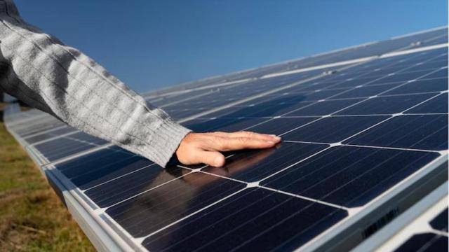 Mano sobre un panel solar