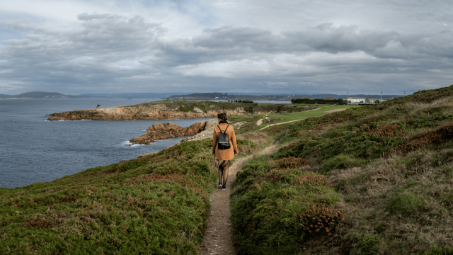 Una mujer realiza una ruta cerca de la costa.