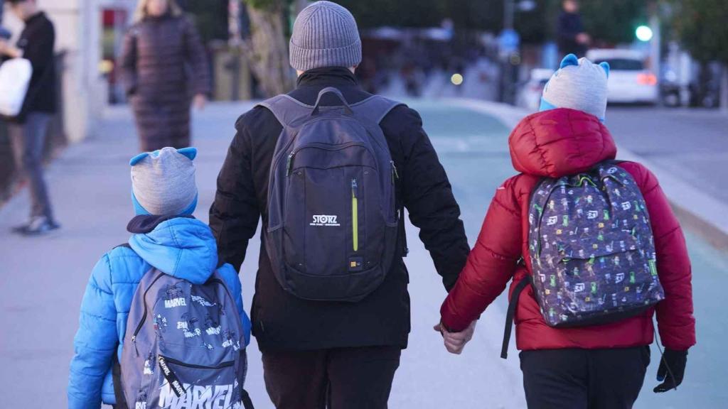 Un adulto pasea con sus hijos